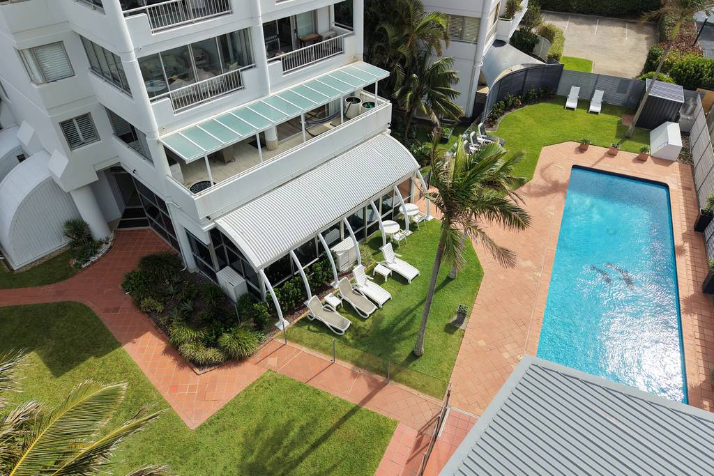 Pool, lawn and palms in the building courtyard