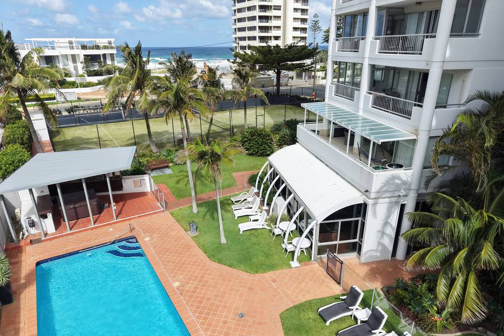 Pool, lawn and white umbrellas in the courtyard