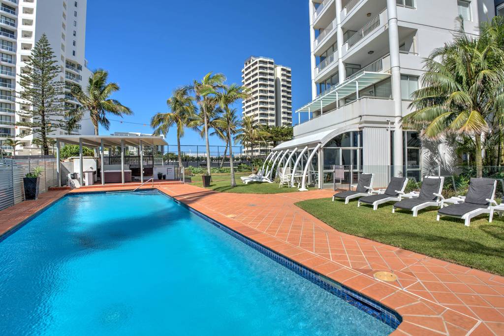 Pool area with loungers and timber deck