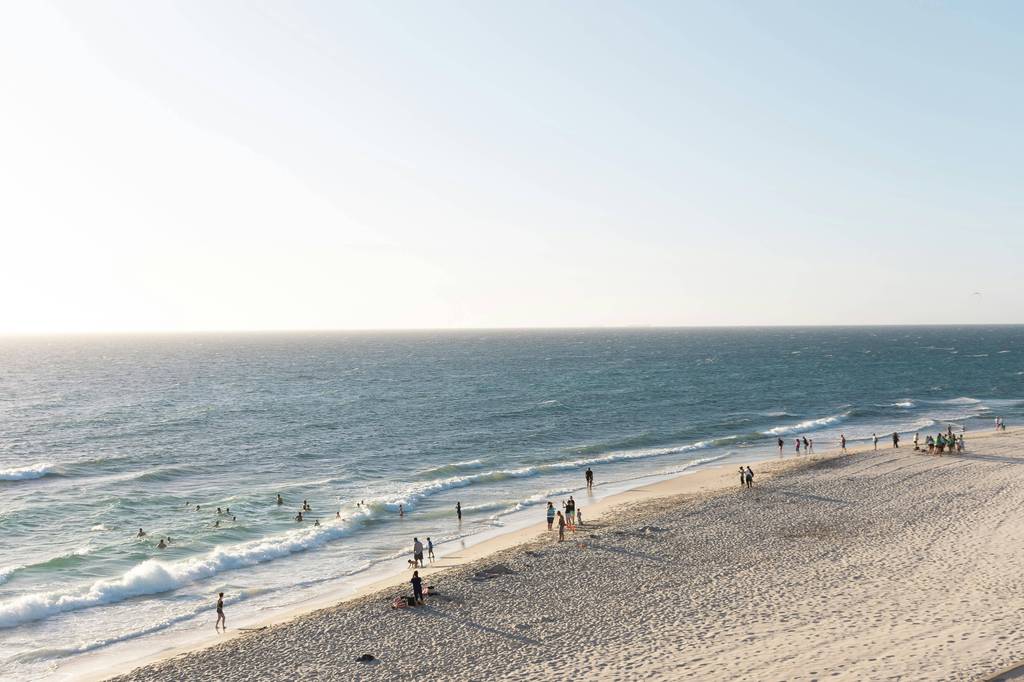 Small group walking along the beach on a clear Gold Coast afternoon