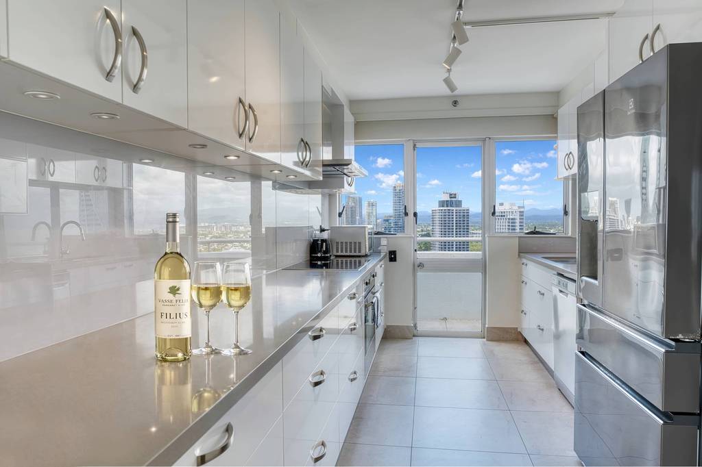 2 Bedroom Superior – kitchen with white cabinetry and city views